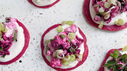 Pink beetroot pancakes topped with whipped 'feta', parsley, and yoghurt