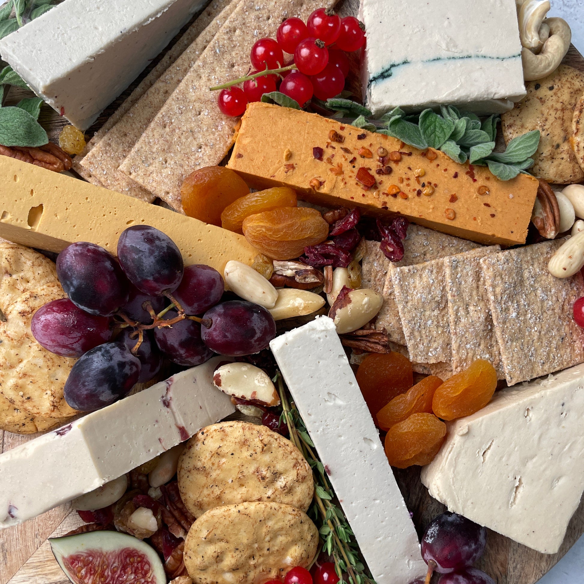Assorted cheese, fruits, and nuts on a wooden board