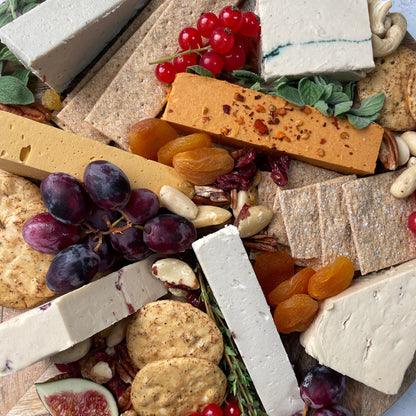 Assorted cheese, fruits, and nuts on a wooden board